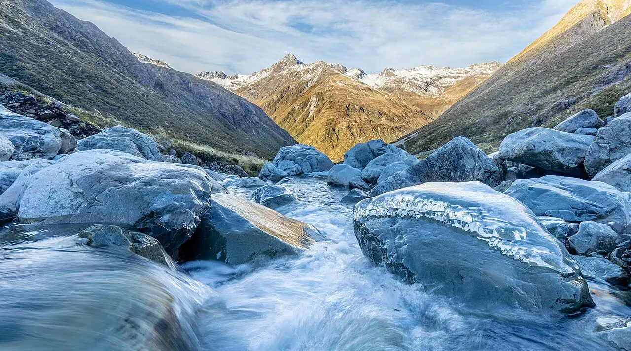 snow capped mountains with a stream in oceania
