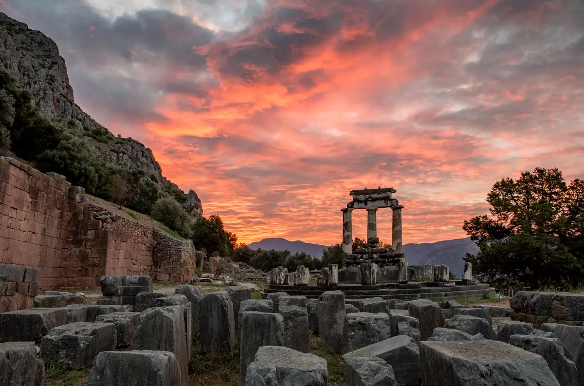 Fiery sunset over the Temple of Athena in Delphi