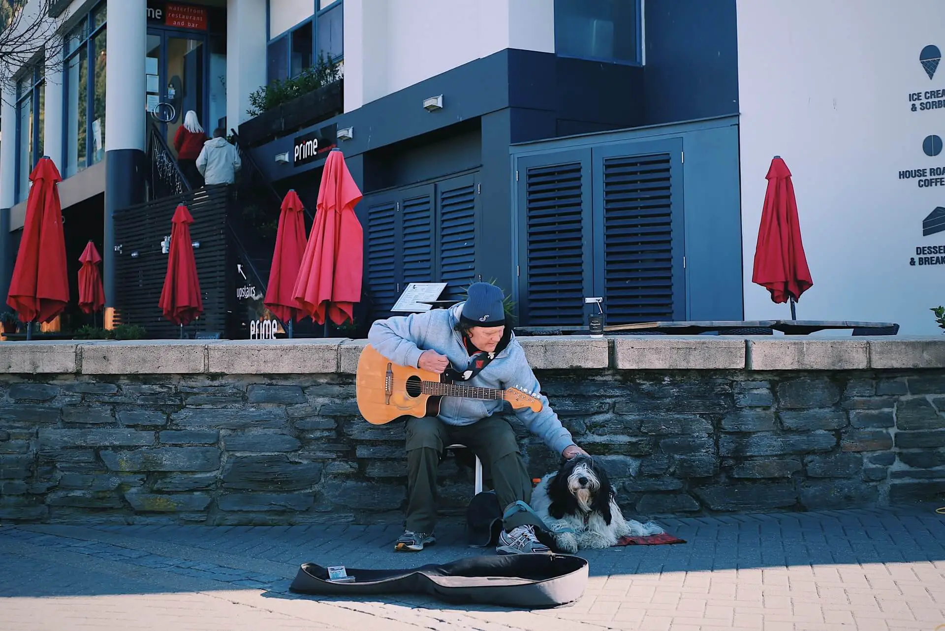 A man working as a travelling busker with his dog