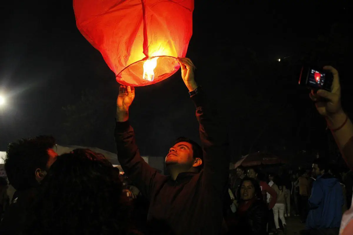 man releasing paper lantern at sao joao festiaval in porto portugal
