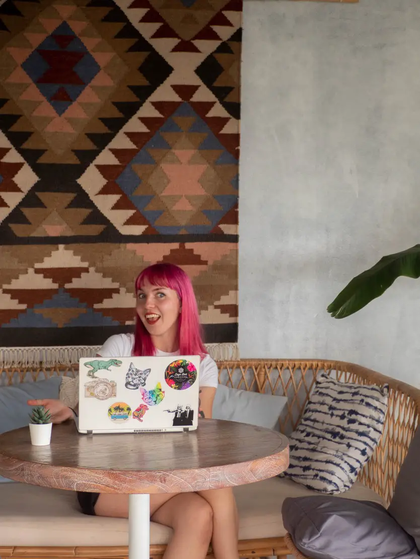 pink haired digital nomad working in a cafe