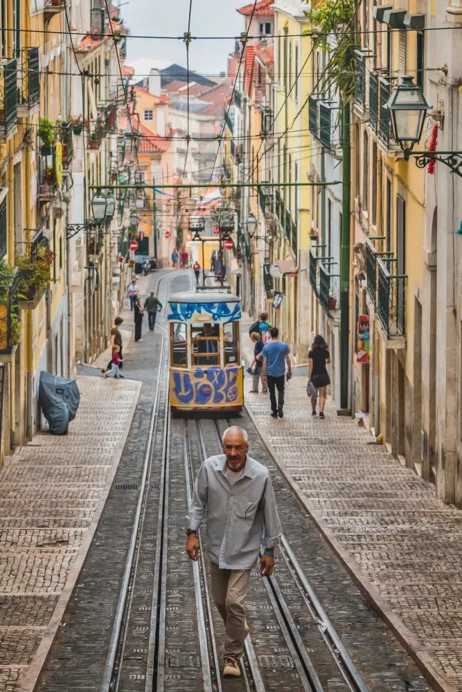 man in front of tram in lisbon portugal