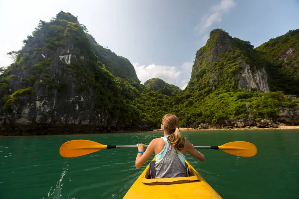 solo female traveller canoeing towards mountains in Vietnam
